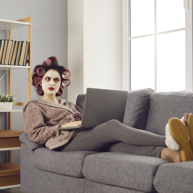 An angry woman on her sofa reading her insurance bill.